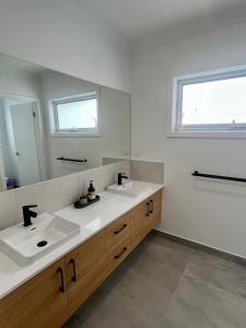 a bathroom with two sinks and a large mirror at Yarrawonga Golf & Lake Getaway in Yarrawonga +28 photos