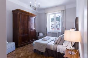 een slaapkamer met een bed, een lamp en een raam bij Grandi Residenze Napoli- Piazza Carità con vista in Napels