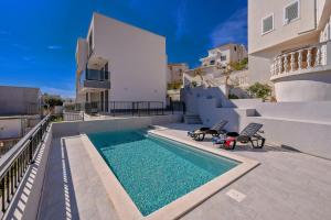 una piscina con 2 sillas junto a una casa en Apartments 5 Stars Lux XYZ, en Rogoznica 32 fotos más