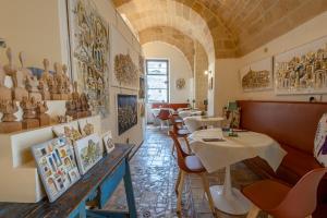 a restaurant with tables and chairs and vases on the wall at L'Artiere Dimore nei Sassi in Matera