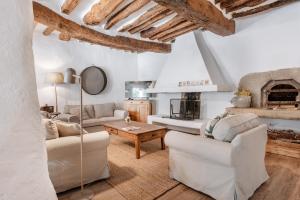 Una sala de estar con muebles blancos y chimenea. en Chez Fanny, en Bédoin
