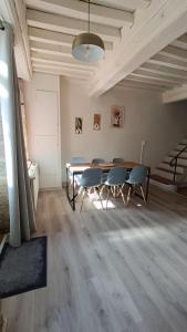 a room with a table and chairs and a staircase at Le gîte de Varanges in Givry +27 photos