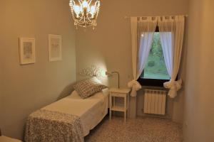 a bedroom with a bed and a window and a chandelier at Casa Verde Conero in Castelfidardo