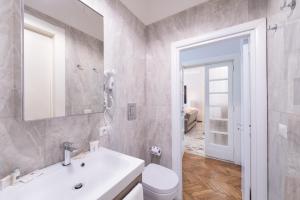 een badkamer met een wastafel, een toilet en een spiegel bij Carità Grandi Residenze Napoli in Napels +14 foto's