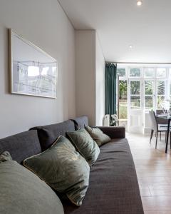a living room with a gray couch with pillows at Kensington Prime Apartments in London +49 photos