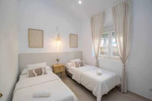a bedroom with two beds and a window at Casa Marinero beach 2 in Torrox Costa
