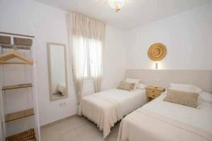 sypialnia z 2 łóżkami, lustrem i oknem w obiekcie Casa Marinero beach 1 w mieście Torrox Costa +37 zdjęć