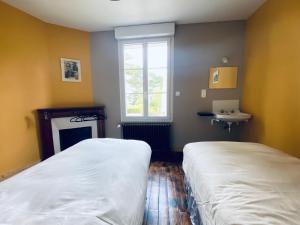 a bedroom with two beds and a fireplace and a window at Kerannette - Spa - Plage et centre ville in Perros-Guirec +2 photos