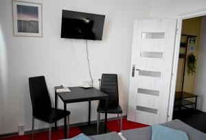 a room with a table and two chairs and a television at Penzión Šariš in Prešov