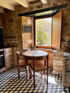 a kitchen with a table and a window at Cabaña Pasiega Lo Macario in Resconorio
