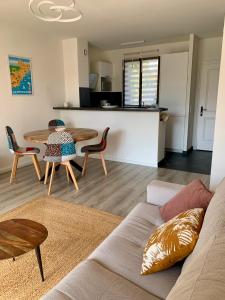 a living room with a couch and a table at 2 pièces, moderne et lumineux avec piscine en résidence privée in Villeneuve-Loubet