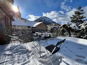 une table et une chaise dans la neige dans l'établissement Au pied des pistes studio et jardin au soleil, à Montgenèvre