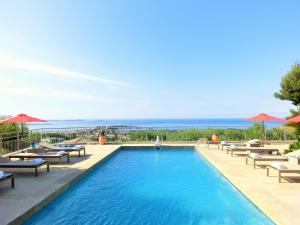 a swimming pool with lounge chairs and umbrellas at Villa Azur Golf in Bandol