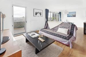 a living room with a couch and a table at Jardin du 8e Ciel - Neuf & Central in Nantes