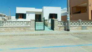 un edificio con una recinzione sul lato di una strada di Villa Casa Vacanza Sea Front a Torre Pali