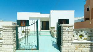 un cancello di fronte a una casa bianca di Villa Casa Vacanza Sea Front a Torre Pali Altre 43 foto