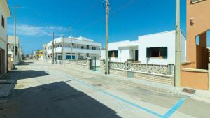 una strada vuota in una città con edifici bianchi di Villa Casa Vacanza Sea Front a Torre Pali