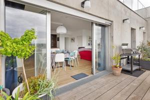 a sliding glass door leading to a dining room at Jardin du 8e Ciel - Neuf & Central in Nantes