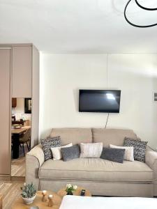 a living room with a couch and a tv on the wall at Tinos Boutique House in Tinos
