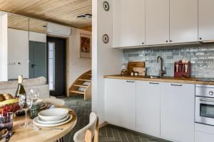 a kitchen and dining room with white cabinets and a table at TatryTop Domy Manowce z jacuzzi in Kościelisko