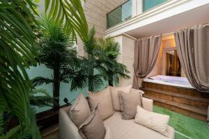een woonkamer met een witte bank en een jacuzzi bij Garden Beach Luxury Apartment in Eilat +19 foto's
