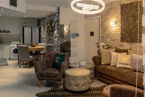 een woonkamer met een bank, stoelen en een tafel bij Garden Beach Luxury Apartment in Eilat
