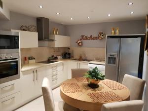 een keuken met een houten tafel en een koelkast bij Garden Beach Luxury Apartment in Eilat