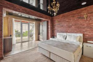 a bedroom with a large bed and a brick wall at Roots Resort in Kobuleti