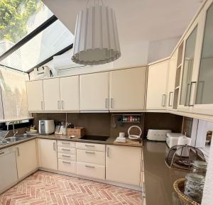 a kitchen with white cabinets and a large window at Quinta do Lago, Victory Village N 63 in Almancil