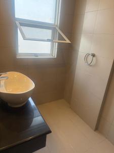 a bathroom with a sink and a shower with a window at Mediterranean Apartments in Islamabad