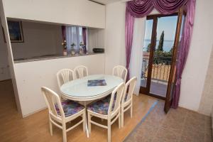 a dining room with a table and chairs and a window at Zara apartma in Podstrana