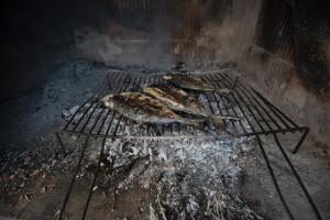three pieces of meat cooking on a grill at Zara apartma in Podstrana