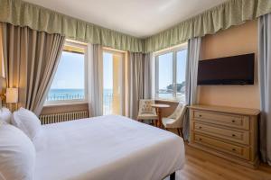 A television and/or entertainment centre at B&B HOTEL Diano Marina Palace