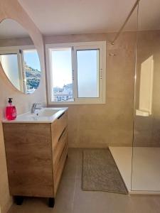 Un baño con lavabo y ducha con espejo. en GLP Postiguet 2, en Alicante