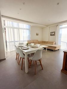Una sala de estar con una mesa y sillas y un sofá. en GLP Postiguet 2, en Alicante