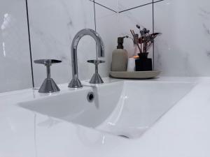 a white sink with two faucets on a counter at The Love Shack in Bongaree +21 photos