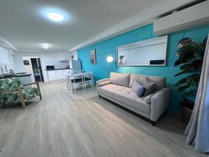 a living room with a couch and a blue wall at The Love Shack in Bongaree
