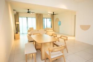 a dining room and living room with a table and chairs at Meritus Residensi Seaview Pent Hauz 3BR 10Pax in Perai