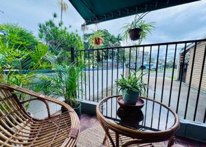 a balcony with two chairs and a table with plants at The Love Shack in Bongaree