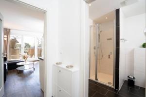 a bathroom with a shower with a glass door at Villa Meeresrauschen Carpe Diem mit großzügiger Terrasse und extragroßem Strandkorb in Pelzerhaken +33 photos
