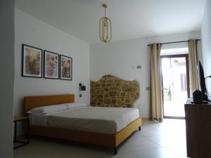 a bedroom with a bed and a tv and a window at Il Cortiletto in Rocca Cilento