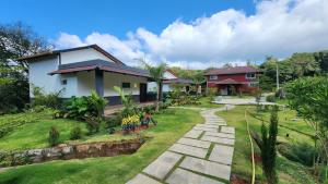 a house with a garden and a walkway at Hong Sau Resort - Luxury Nature Escape, Sakleshpur in Sakleshpur