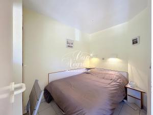 a bedroom with a bed with a sign that reads take care at Appartement T2 rénové vue mer pour 4 personnes a 50m de la plage de Pramousquier in Rayol-Canadel-sur-Mer +12 photos