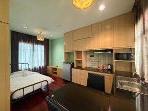 a small kitchen with a bed and a sink at Greenview Ekkamai10 Suite in Bangkok