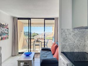 a living room with a couch and a table at Appartement T2 rénové vue mer pour 4 personnes a 50m de la plage de Pramousquier in Rayol-Canadel-sur-Mer
