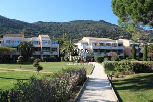 a view of a resort with mountains in the background at Appartement T2 rénové vue mer pour 4 personnes a 50m de la plage de Pramousquier in Rayol-Canadel-sur-Mer