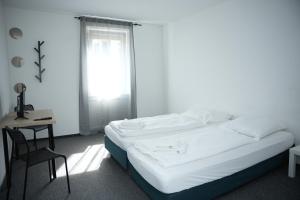 una camera da letto con un letto, una sedia e una finestra di Ring Hotel a Wiesbaden