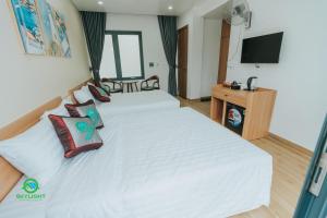 a bedroom with a large white bed with pillows at Homestay SkyLight in Dong Hoi