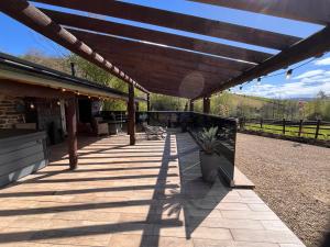 a patio with a roof with a plant on it at Tanyard Barn - Luxury Hot Tub & Secure Dog Field Included in Old Glossop