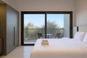 ドバイにあるSleek New Studio in Meydan, Fully Equipped and Spaciousのベッドルーム1室(ベッド1台付)、バルコニー(テーブル付)